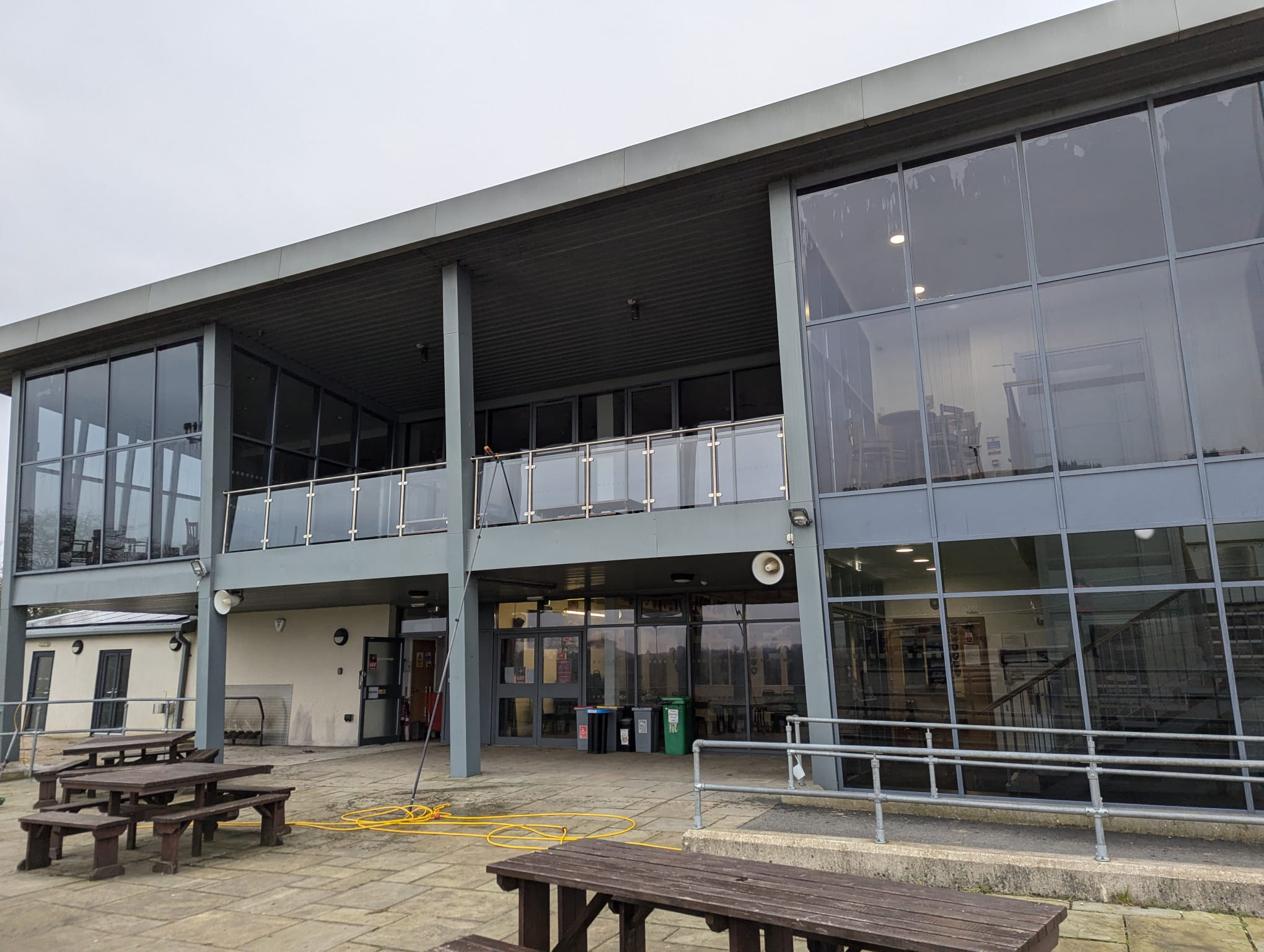 Large exterior windows being cleaned from the ground with a long pole